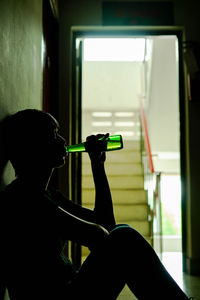 Rear view of man playing window at home