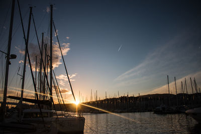 Sailboats in marina at sunset