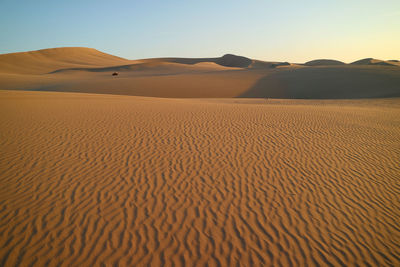 Sand dune in desert against clear sky