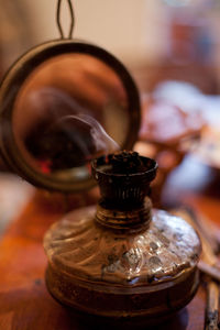 Close-up of smoke emitting container on table