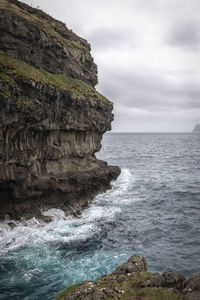 Rock formation on sea against sky