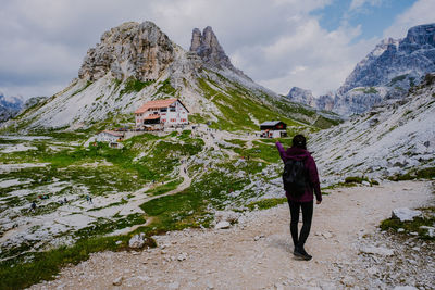 Rear view of person on snowcapped mountain against sky