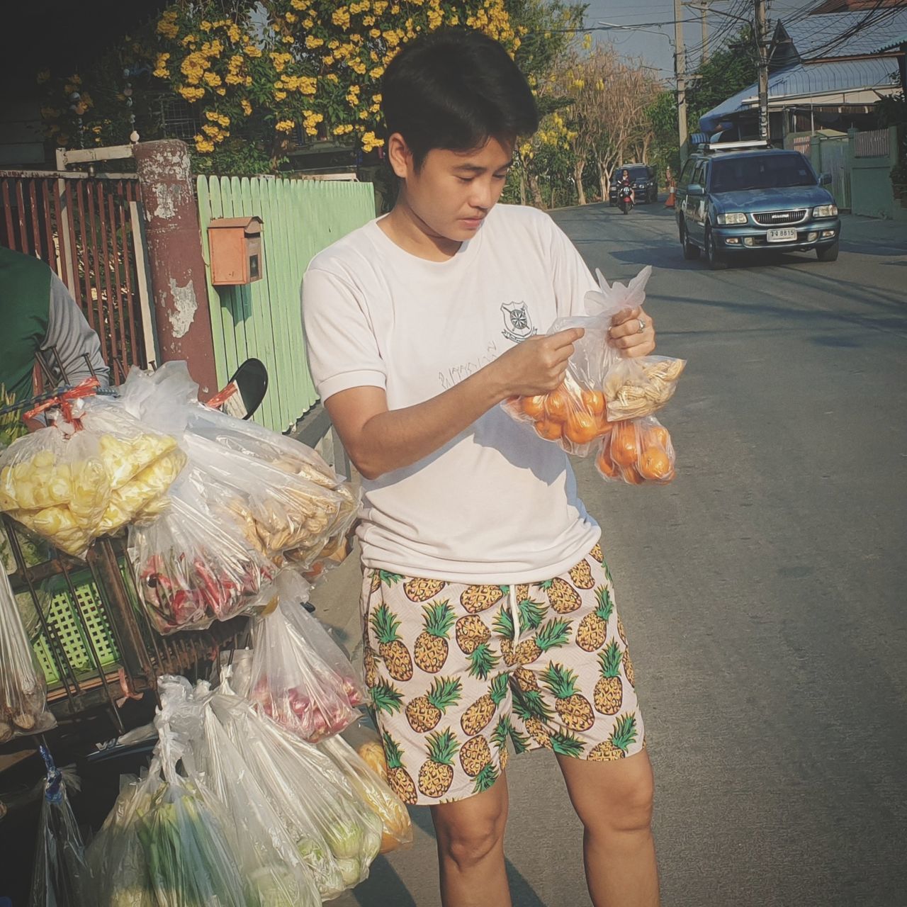 real people, food, food and drink, three quarter length, holding, street, men, casual clothing, city, people, market, retail, standing, lifestyles, front view, transportation, road, mode of transportation, for sale, street food, outdoors