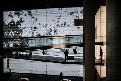 People walking in city seen through glass