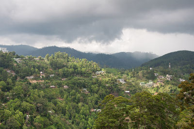 Scenic view of townscape and mountains against sky