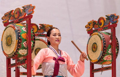 Full length of young woman holding carousel in amusement park