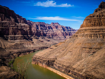 Rocky mountains against cloudy sky on sunny day at grand canyon national park