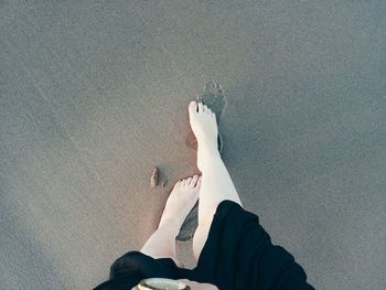 Low section of woman lying on sand