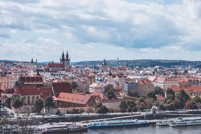 Buildings by river against sky in city