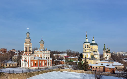 View of buildings in city against sky during winter