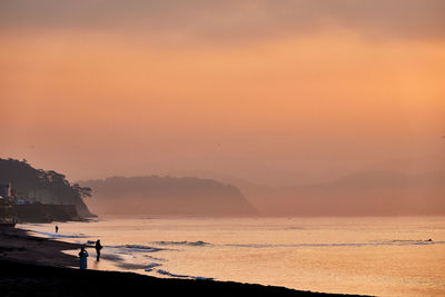 Scenic view of beach against sky during sunset