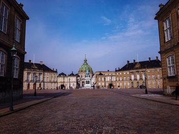 View of city street and buildings against sky