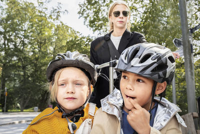 Mother riding bicycle with children in carriage