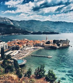 High angle view of townscape by sea against sky