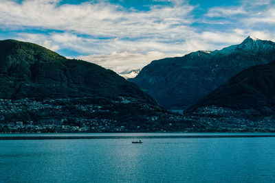 Scenic view of sea by mountains against sky