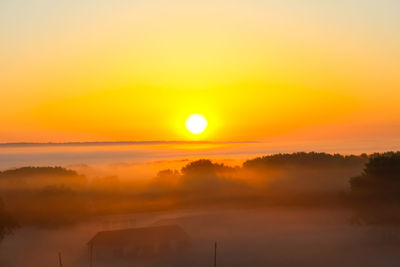 Scenic view of silhouette landscape against orange sky