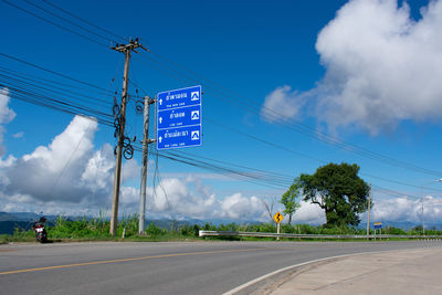 Information sign on road against sky