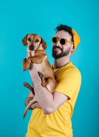 Portrait of man wearing sunglasses against blue background