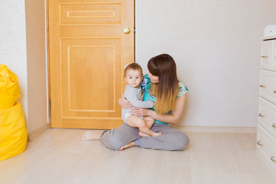 Full length of a woman sitting on door