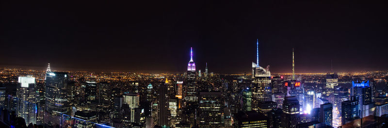 Illuminated cityscape against sky at night