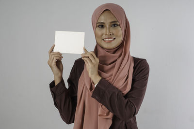 Portrait of a smiling young woman against white background