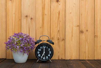 Close-up of clock on wooden wall
