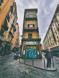 Man standing on street against buildings in city