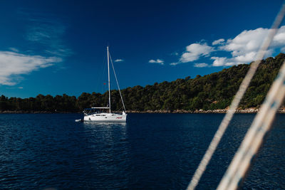 Boats sailing on sea against blue sky