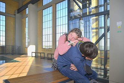 Tired siblings on family trip. railway station in europe. authentic image. not photo studio shot