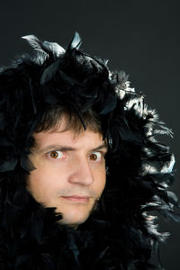 Close-up portrait of young man against black background