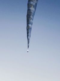Low angle view of icicles against clear sky