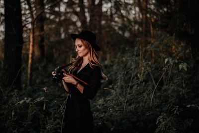 Young woman looking away in forest