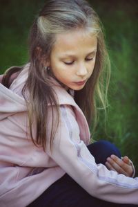 High angle view of girl looking down while crouching on land