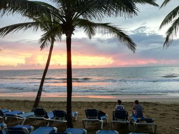 Palm trees on beach against sky during sunrise 