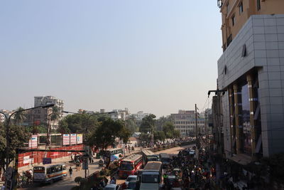 Traffic on road amidst buildings against sky