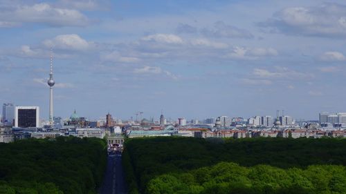 View of city buildings against cloudy sky