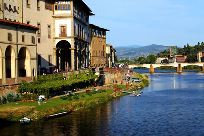 Ponte alle grazie over arno river by buildings at tuscany against clear sky