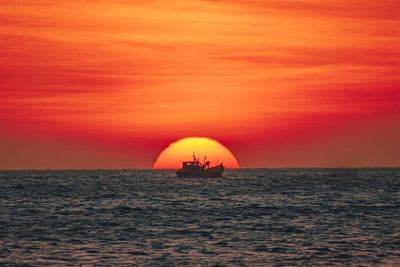 Scenic view of sea against orange sky