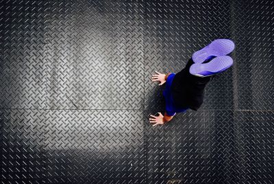 High angle view of man doing handstand on diamond plate