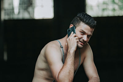 Portrait of shirtless young man sitting at home