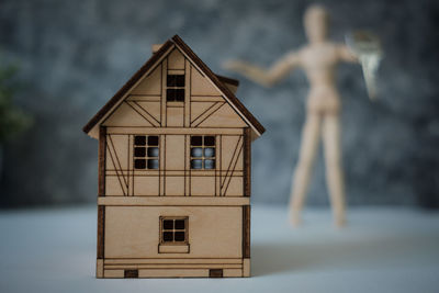 Close-up of model home with figurine in background