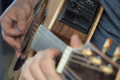 Close-up of human hand playing guitar