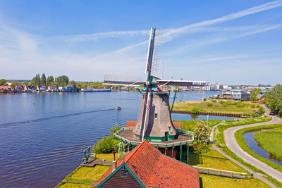 Sailboats on bridge over river against sky in city