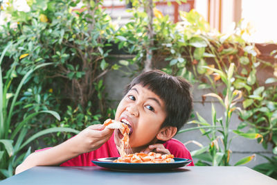 Portrait of young woman eating food in plate