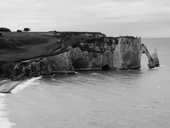 Rock formations in sea against sky