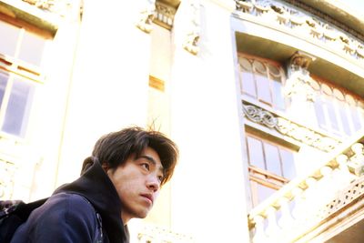 Portrait of young man against window