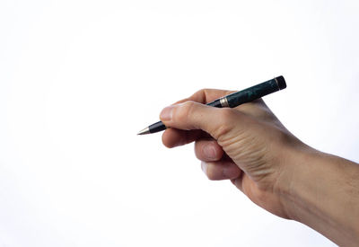 Close-up of hand holding pen against white background