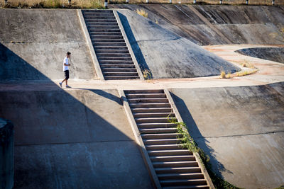 Side view of teenage boy walking on dam