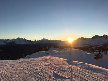 Scenic view of snowcapped mountains against clear sky during sunset