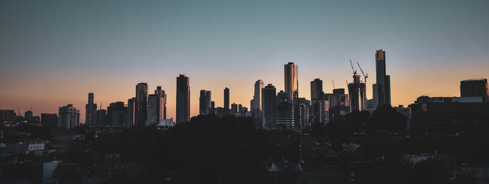 View of buildings in city against sky during sunset